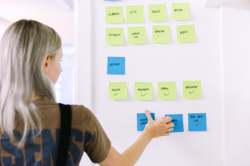 Person using sticky notes on whiteboard