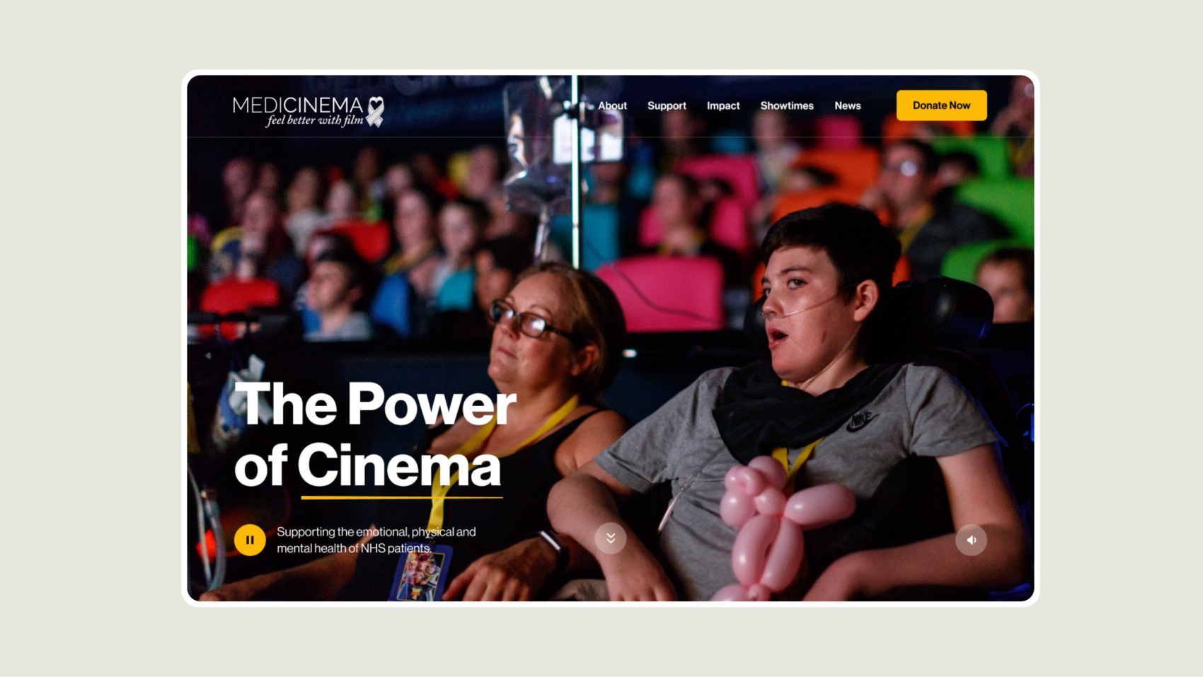 A design mockup of the MediCinema homepage showing two people sat watching a film at a hospital cinema. 